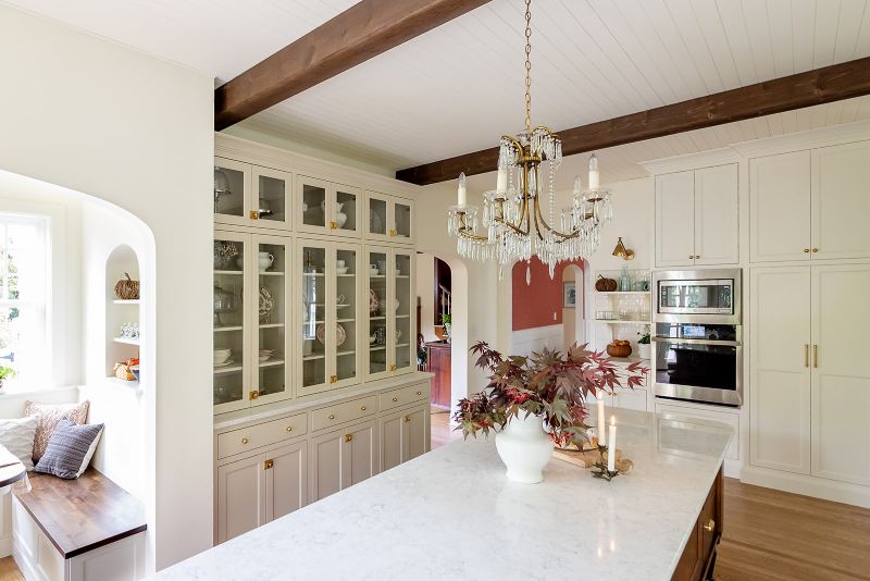 View from the kitchen island into the adjoining dining room with gorgeous antique chandelier over the island.