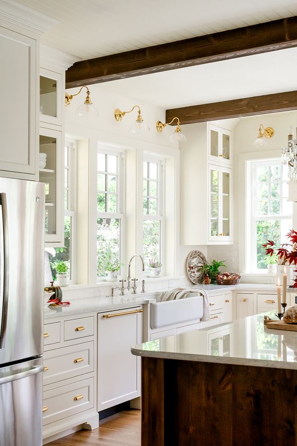 Spacious kitchen with a sink positioned under wide windows, showcasing light-filled design.