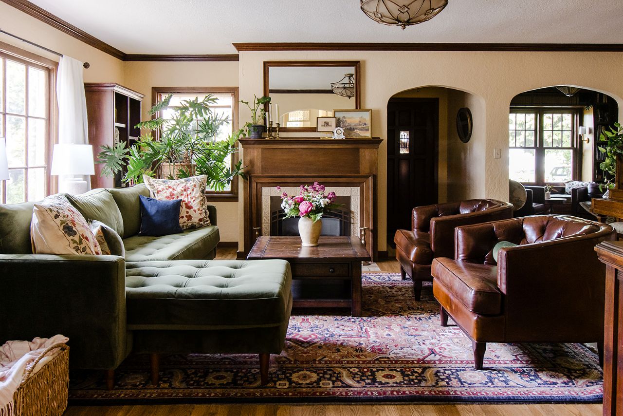 Traditional living room, with mahogany trim, a fireplace, and arched entryways that are true to the era of this 1930's home.