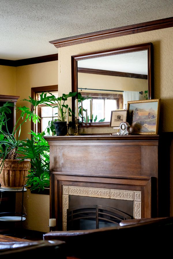 Wood mantle with historic trim and mirror above.
