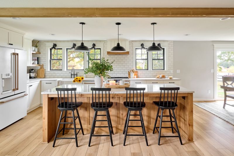Light wood island with white quartz countertops and black barstool seating.
