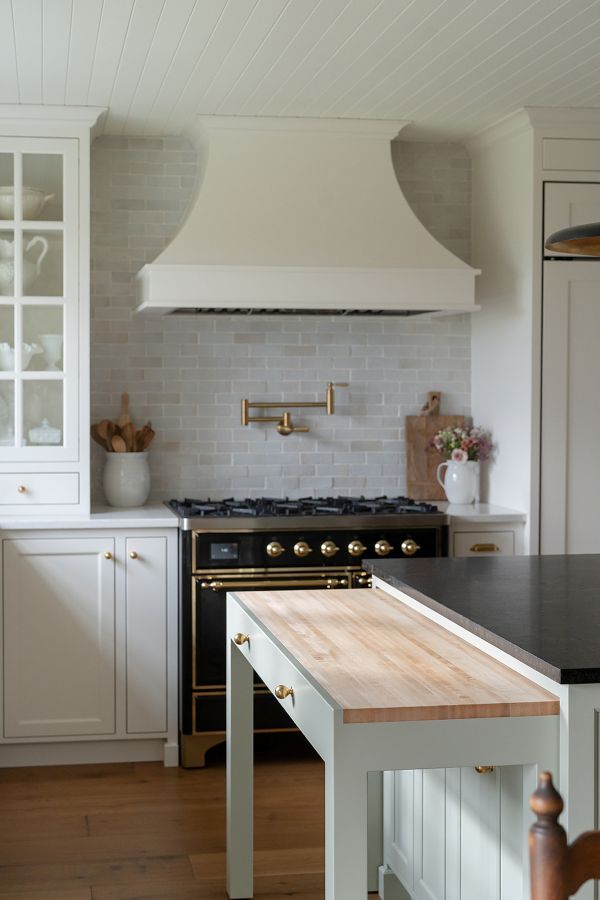 Rollout hidden baking counter with butcher block countertop at the end of a kitchen island.
