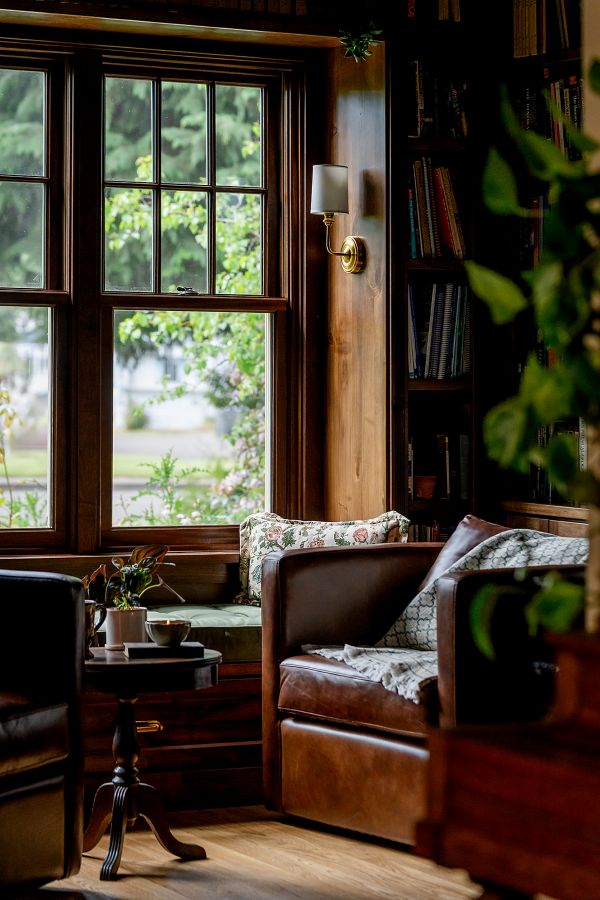Club chairs in leather make up the cozy seating area of a study.