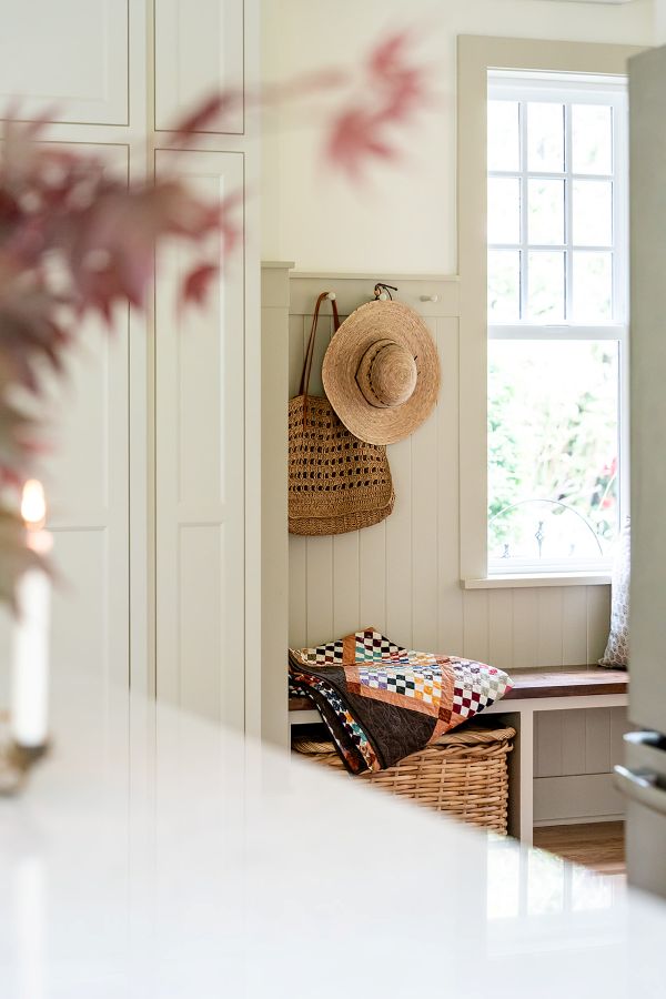 Charming vestibule garden entry featuring a bench and wooden peg rail for hat and coat storage.