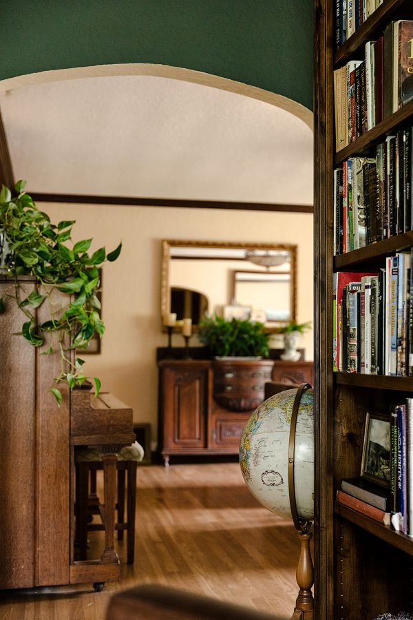 English cottage study with custom woodwork, looking out to living room with cozy furnishings and warm accents.