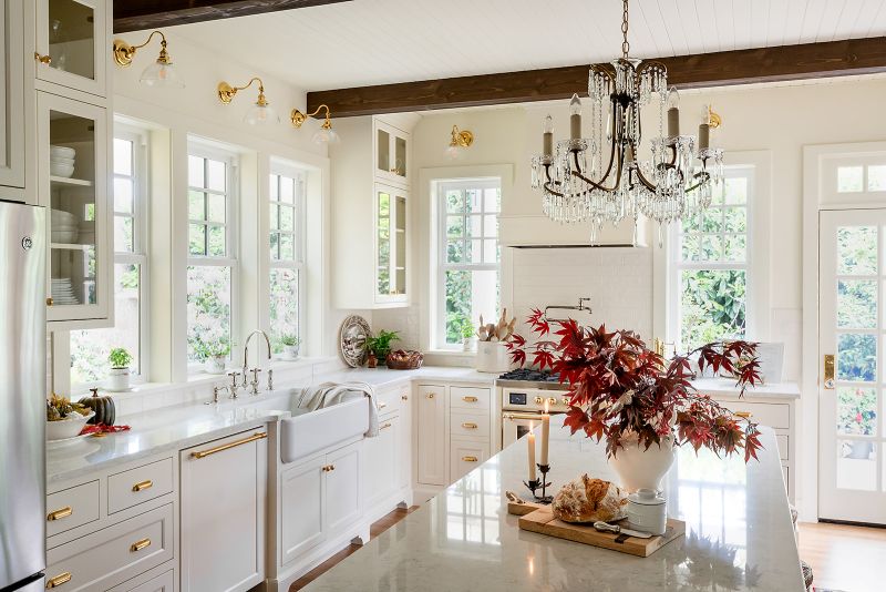 Overall view of kitchen, multiple windows offering view of garden.