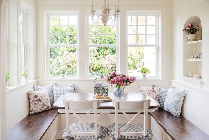 Bright breakfast nook seating with windows all around provides a cheery place to enjoy a meal and feel the outdoor ambiance