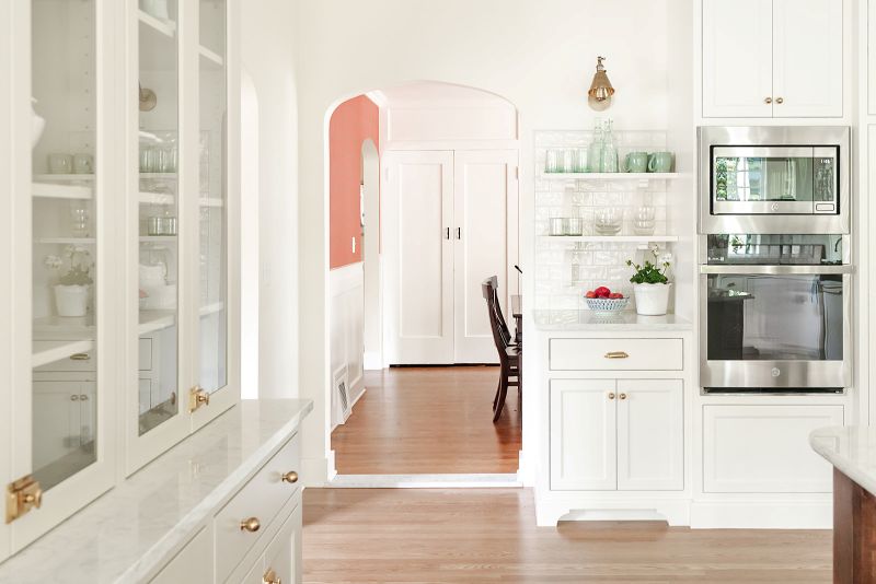 Open shelving, backed by white subway tile creates a perfect drink station at the perimeter of the kitchen