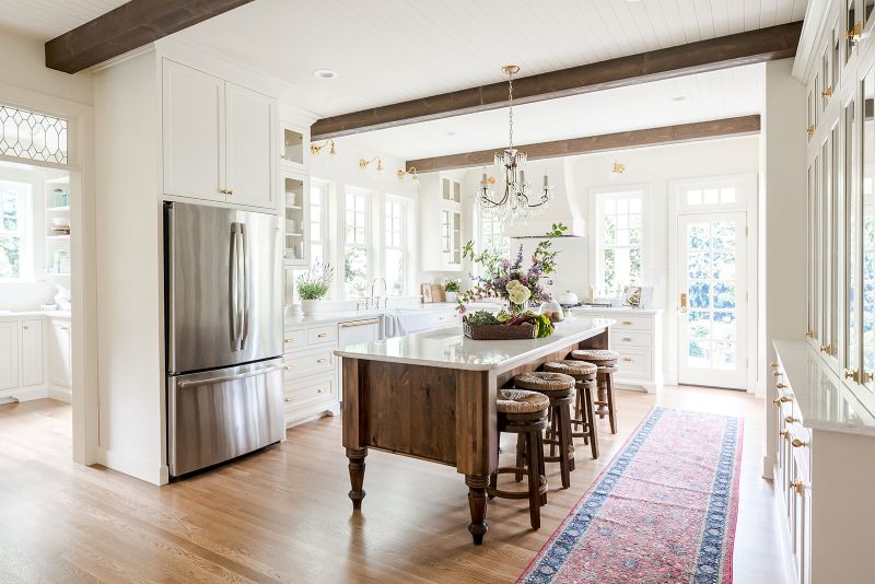 Creamy white cottage style kitchen with tongue and groove ceiling and open wood beams