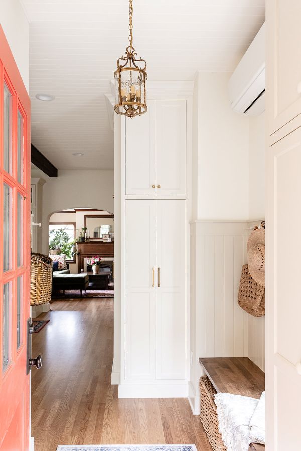 View from the back garden entry into the vestibule with wooden bench seat and peg rail for storage