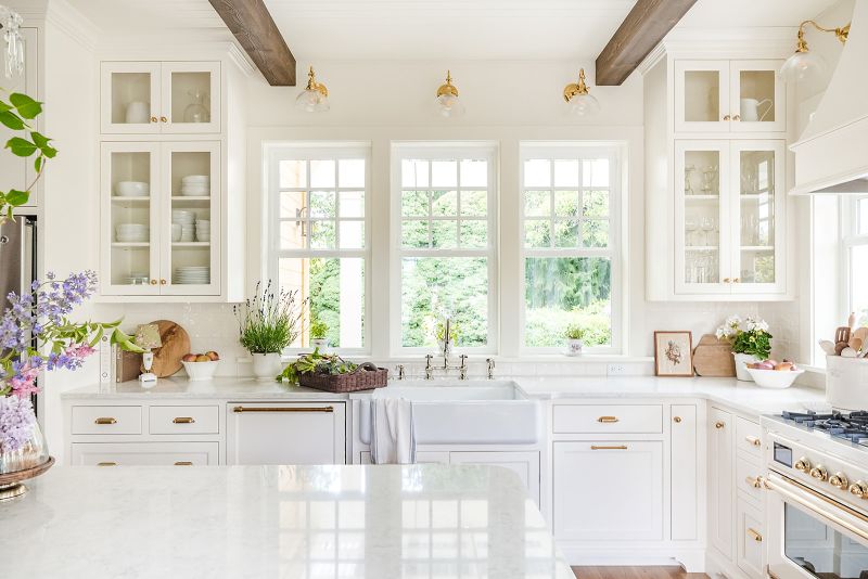 Glass front upper cabinets display white dishware and glassware