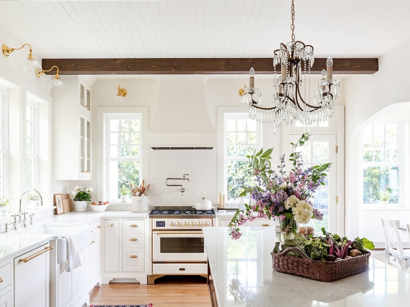 Creamy white storybook English cottage kitchen with vintage chandelier