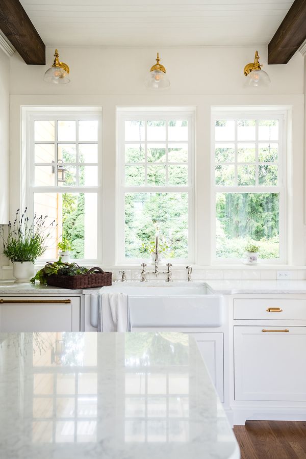 Three windows over kitchen sink that overlook the backyard garden area
