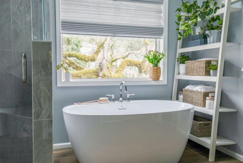 Free standing bathtub with white ladder-style shelving.