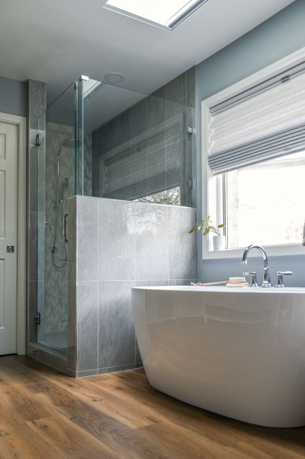 Angled photo showing gorgeous blue gray tile shower and free-standing bathtub.