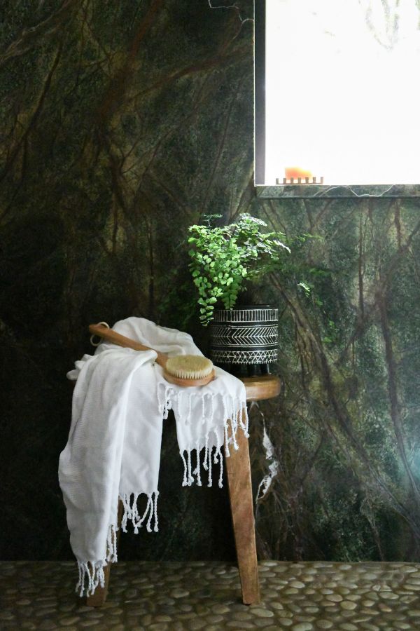 Wooden shower stool under window.