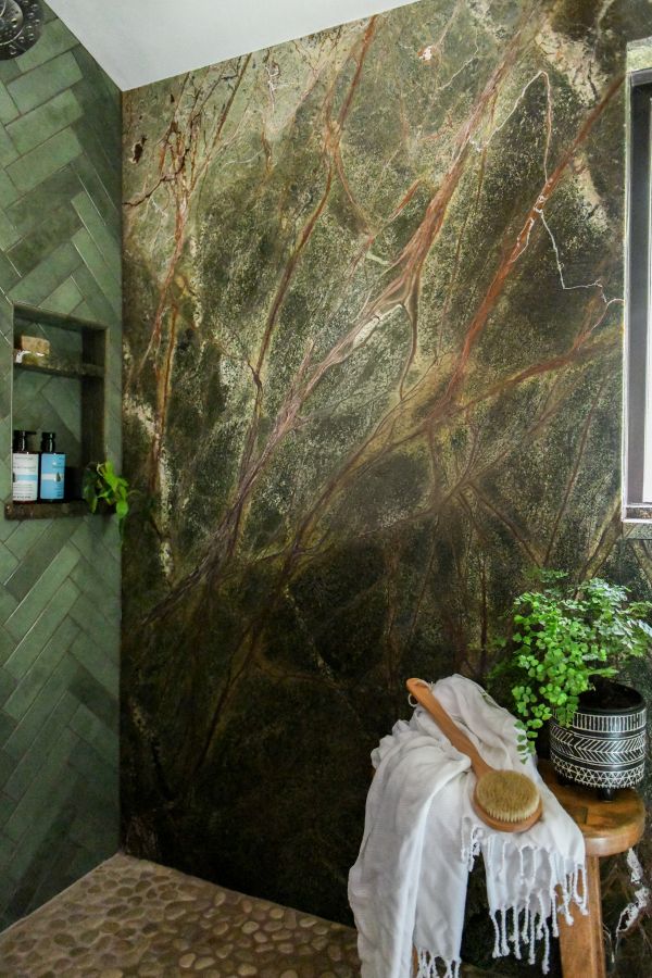 Vertical corner view of shower, niche, and stool.
