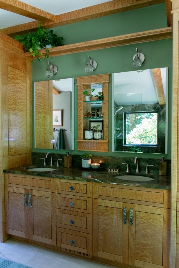 Deep green wall paint compliments the forest-like elements of this bathroom.